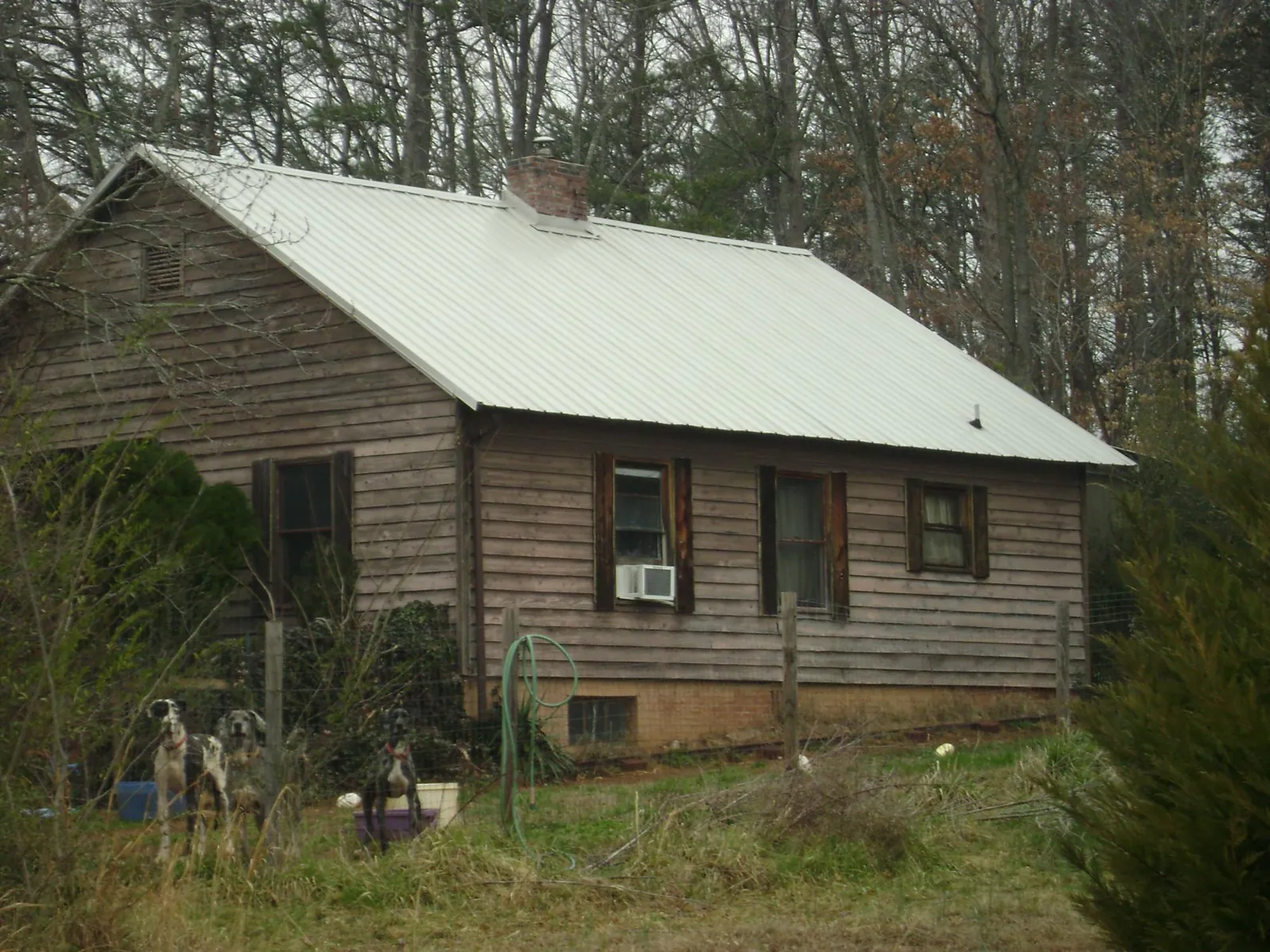 White metal roof on an old wood sided farmhouse, from a Metal Roof Installation job in Cuero
